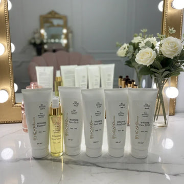 Icaro skincare set with cleanser, toner, scrub, and cream tubes on a vanity with roses