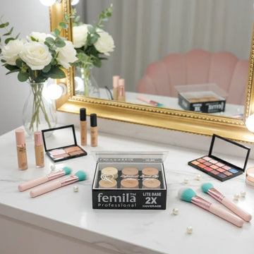 Vanity table with makeup brushes, foundation, femila Professional palette, and white roses at Icaro