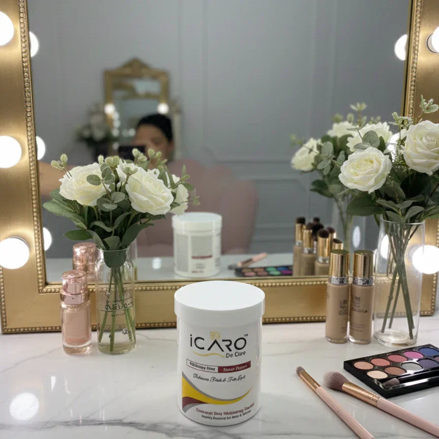 Icaro beauty product on vanity with makeup, flowers, and mirror with lights